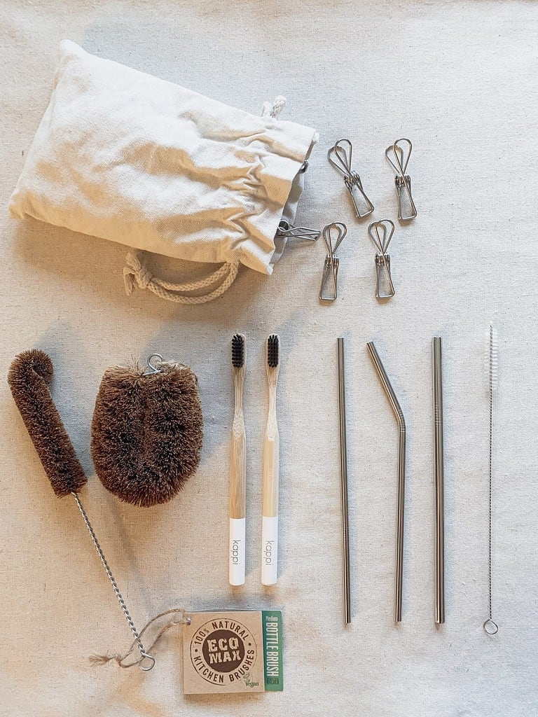 Image is of zero waste items such as metal pegs, kitchen scrubbers, toothbrushes and metal straws.