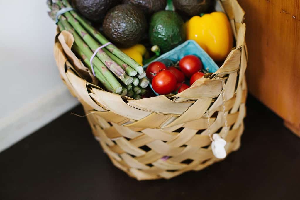 Image is of food hamper with various vegetables such as tomatoes, capsicum and asparagus.