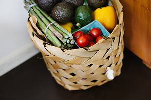 Image is of food hamper with various vegetables such as tomatoes, capsicum and asparagus.