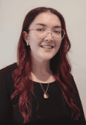 A person with long red hair wearing glasses

Description automatically generated